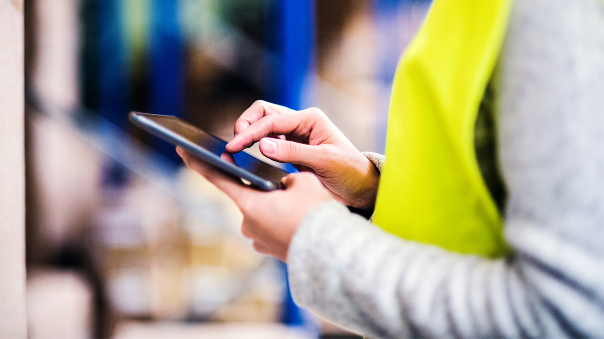 Woman warehouse worker with tablet.